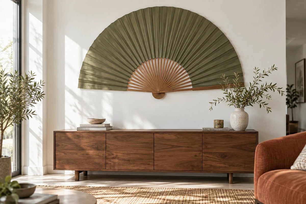 Moss green hanging fan wall decor above a walnut sideboard in a calm Japandi living room