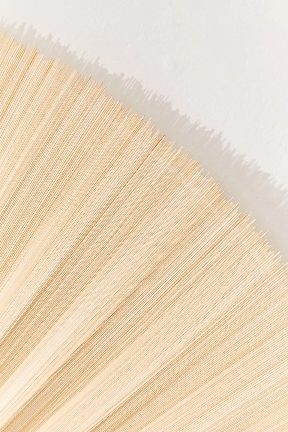 Close-up of the finely pleated natural bamboo panel on an ERISO hanging wall fan