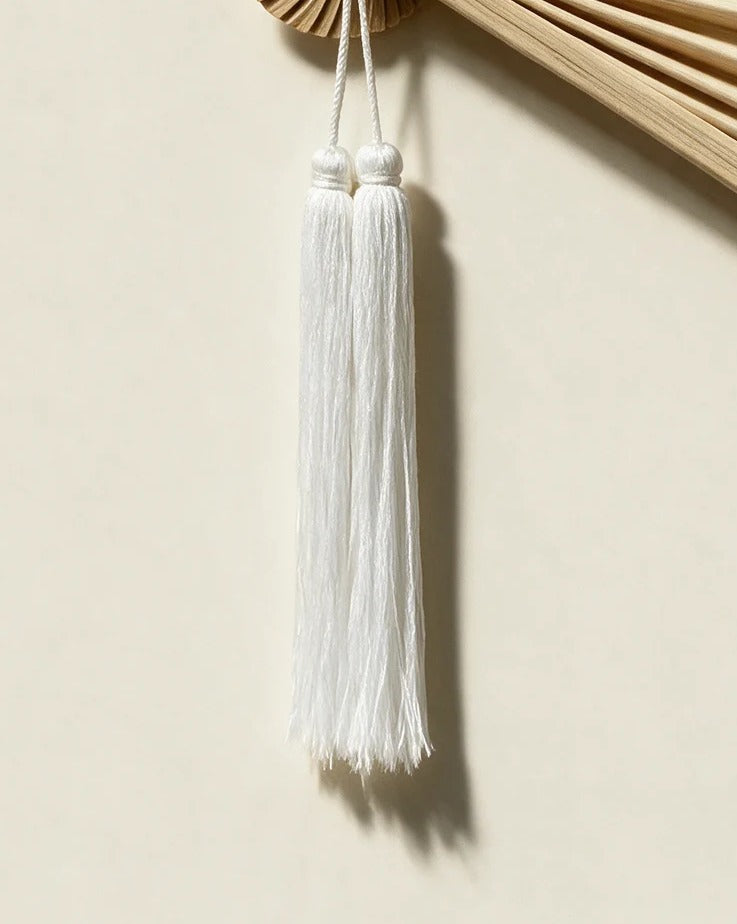 Close-up of the white double tassel and braided cord on an ERISO hanging wall fan