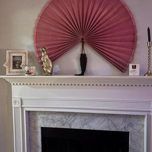 Customer photo: Magenta hanging wall fan above a white fireplace mantel
